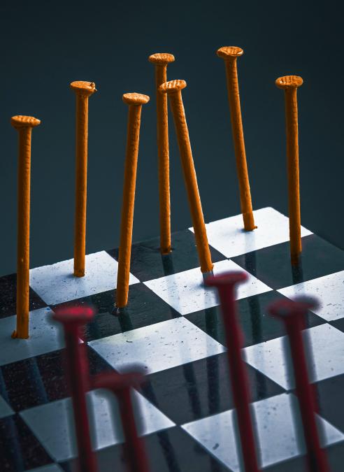 nails in orange and red nailed to a checker board game