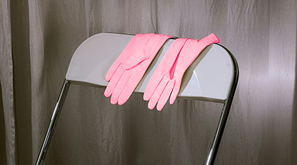 pink ladies leather gloves resting on the back of a folding chair