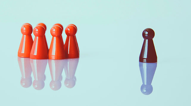 orange game pieces in a group and a black one all by itself