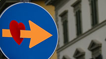 colorful street sign with an arrow through a heart pointing to the right